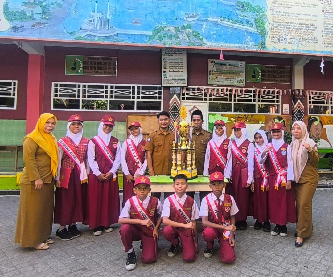 Sejumlah siswa berseragam merah putih bersama guru SDN Kalukuang 2 berfoto di halaman sekolah dengan piala di tengah sebagai simbol kesiapan mengikuti program Tahsin Tahfidz Al-Qur’an di Makassar.