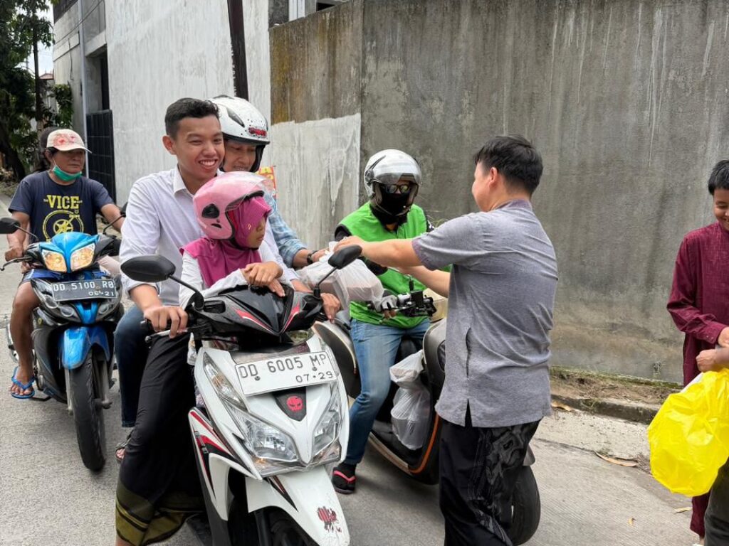 Warga mengantre menerima paket nasi Jumat Berkah Benteng Kupa Group di Makassar