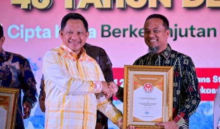 Menteri Dalam Negeri Tito Karnavian menyerahkan penghargaan Dekranas kepada Gubernur Sulawesi Selatan Andi Sudirman Sulaiman pada penutupan Syukuran Dekranas ke-46 di Trans Studio Mall Makassar, Minggu (12/7/2026).